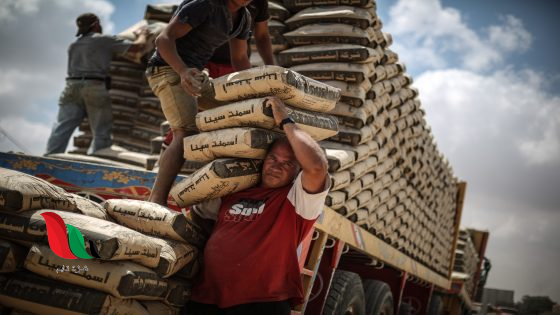 RAFAH, GAZA - JUNE 14: Palestinian workers adjust bags of cement loaded on a truck that entered the Rafah from Egypt on June 14, 2015, after Egyptian authorities reopened the Rafah crossing on the border with the Gaza Strip on June 13 for three days. (Photo by Ali Hassan/Anadolu Agency/Getty Images)